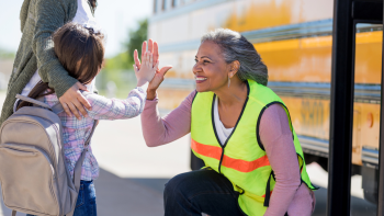 student high fiving the bus driver on the first day of school