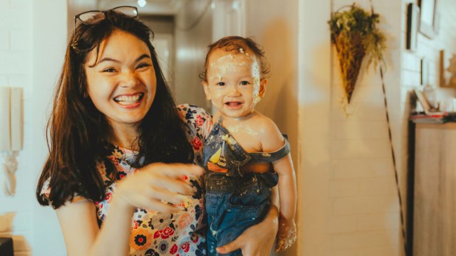 smiling mom holding messy baby