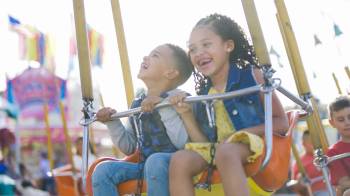 Two kids ride swings at the Evergreen State Fair over Labor Day weekend in Seattle