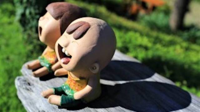 two creepy smiling clay dolls found along dolls head trail, an atlanta hidden gem