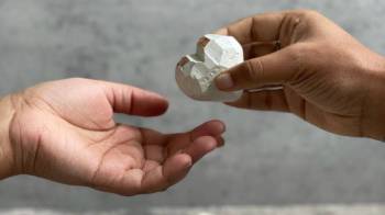 a hand passes a heart shaped soap to another hand