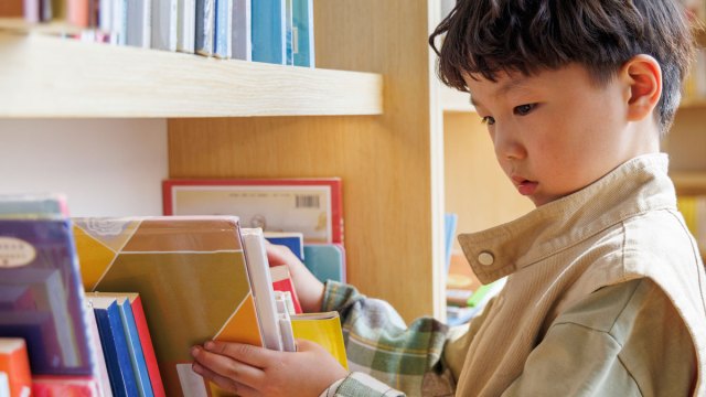 boy looking at books in a bookshelf