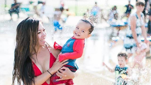 mother holding baby at splash pad