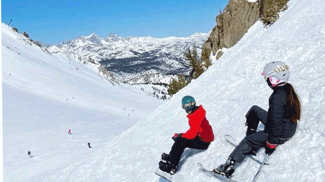 two kids on the side of a mountain skiing and snowboarding