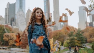 girl standing in Central Park in NYC on fall day