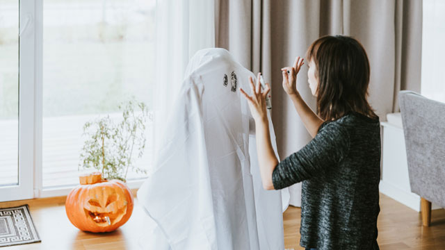 mom telling son in a ghost costume halloween jokes
