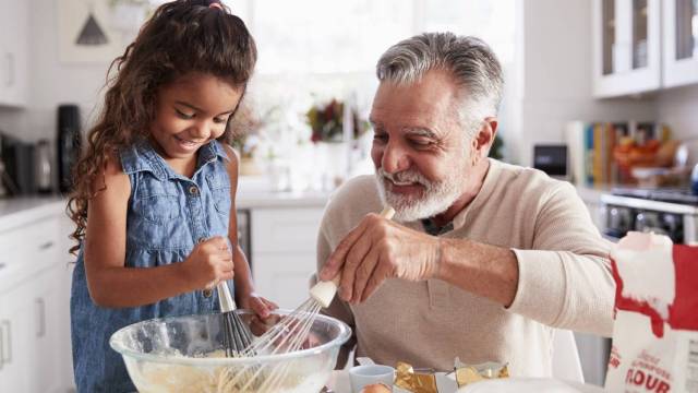 a grandparent and granddaughter stir up dinner in a bowl