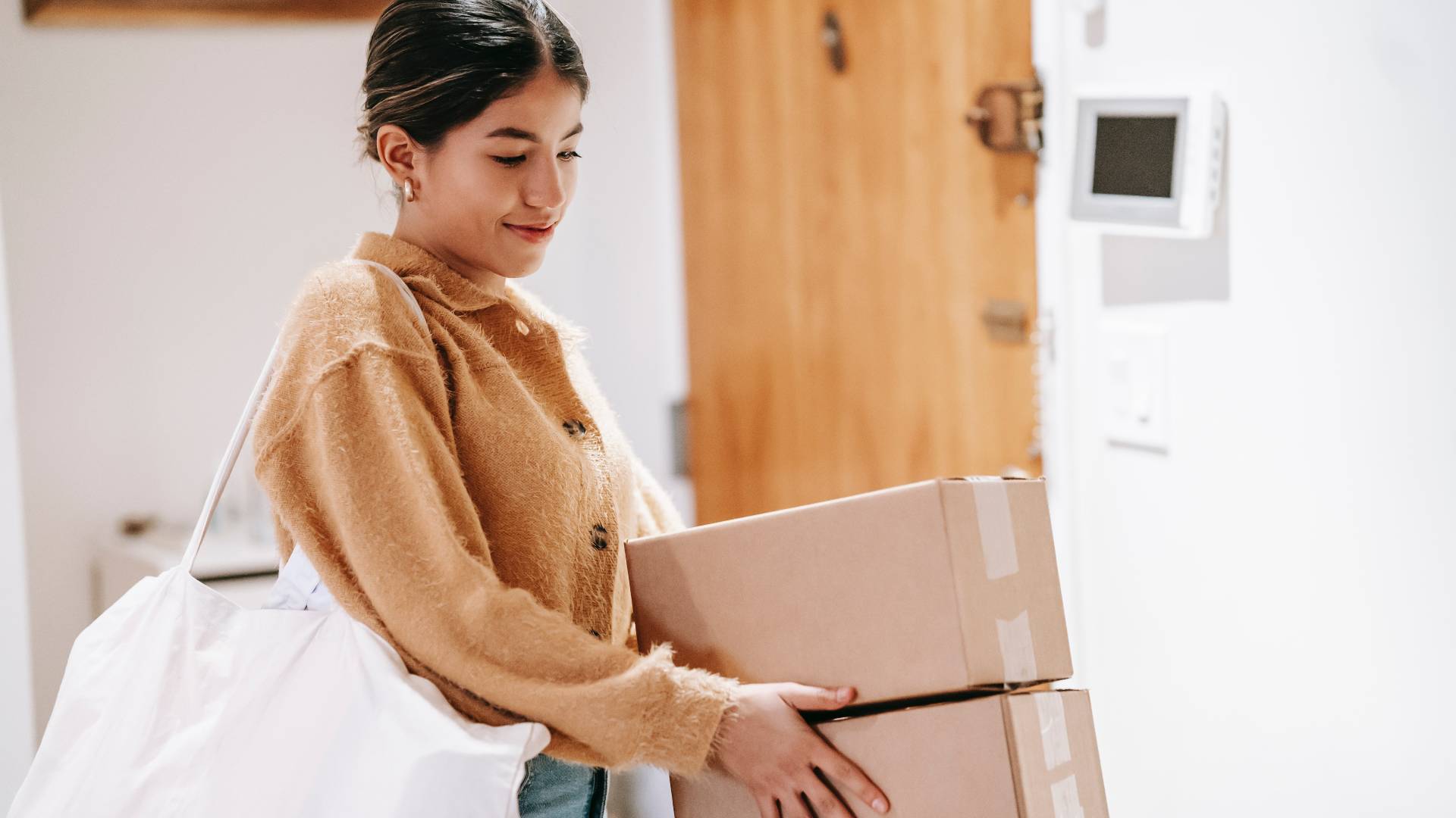 a woman holds two stacked cardboard boxes to sell 