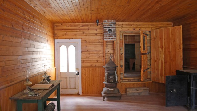 Ghost town scene showing room with furnace, wooden walls, white door and desk