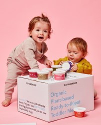 two babies leaning against Tiny Organics box