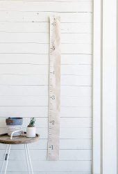 shiplap wall with growth chart and small table