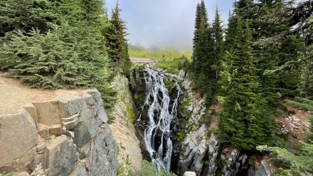 Mrytle Falls waterfall in Mt. Rainier National Park with misty clouds and trees on both sides