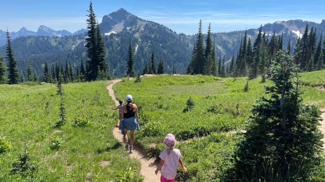 a mom and kids hike along a trail with Mt. Rainier in the background