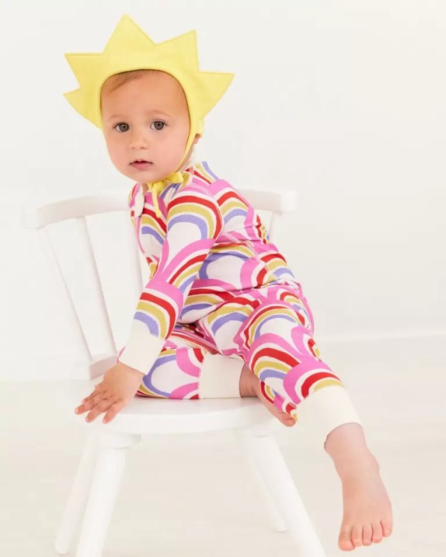 Baby in rainbow pajamas and sun bonnet