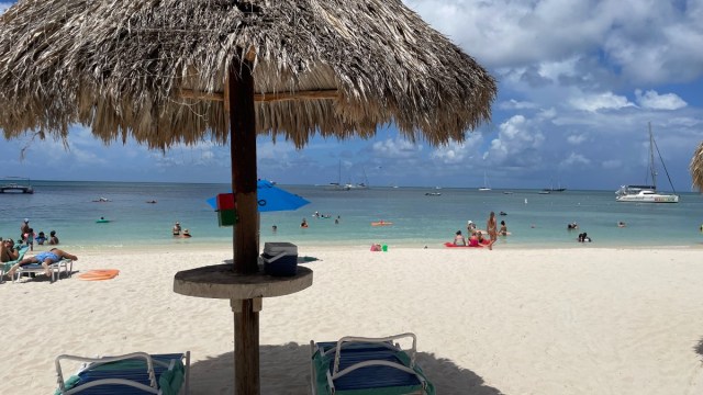 two chairs reclined in the shade of a beach palapa at Hyatt Regency Resort in Aruba