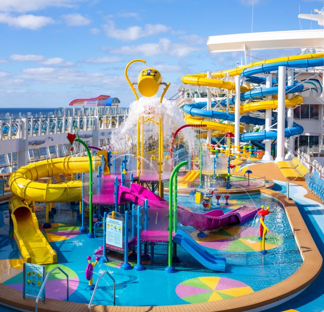Multiple yellow and pink waterslides and water coming from top on Splashaway Bay, Wonder of the Seas cruise ship