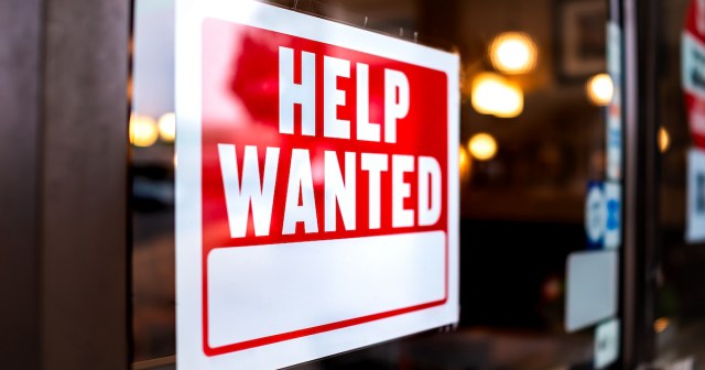 A "help wanted" sign posted in a store window