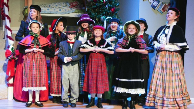 a group of performers dressed a carolers at shows in seattle east side studio present twas the night