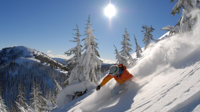 Skier on snow laden mountain slope