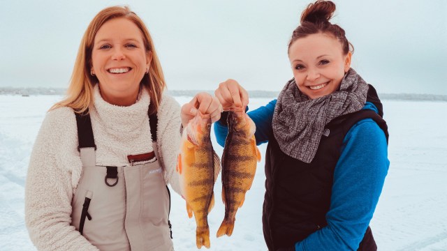 ผู้หญิงสองคนถือปลาที่พวกเขาจับได้