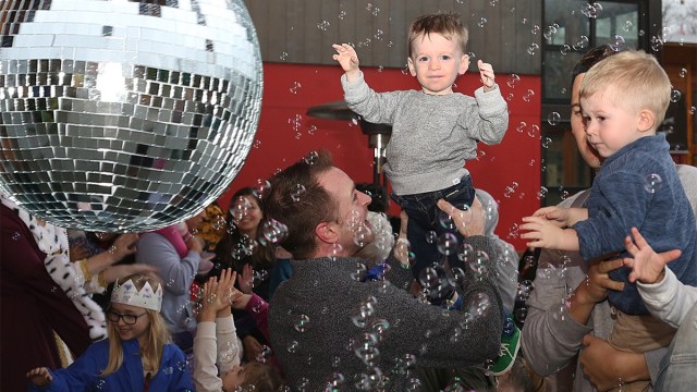 Portland new Years eve where a young boy near a disco ball bubbles falling all around