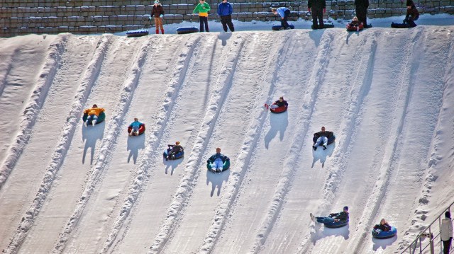 Children tubing in their lanes on snow laden slopes