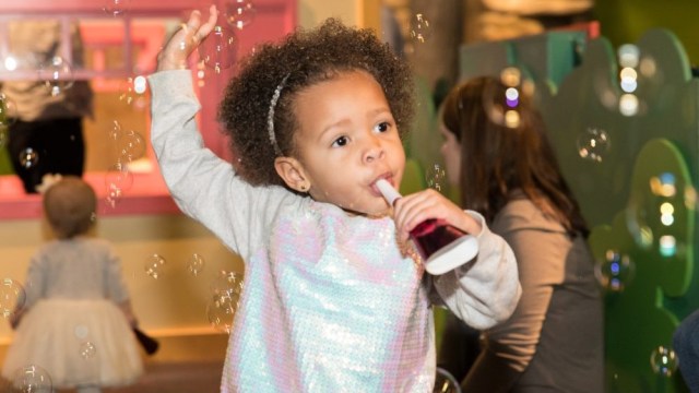 a young girl blows a horn during a black history month in atlanta event at children's museum of atlanta