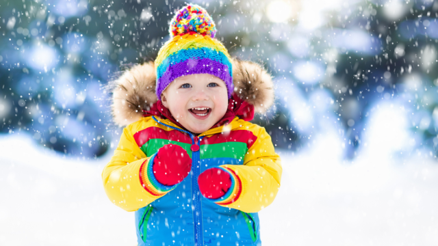 child laughing in the snow at winter jokes for kids