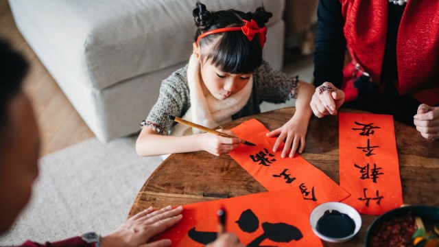 a girl paints a red card for luck during lunar new year seattle activities