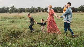 young family walking through field
