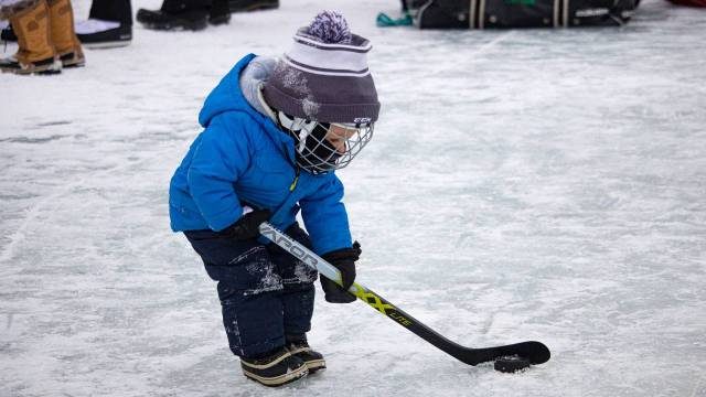 toddler playing pond hockey