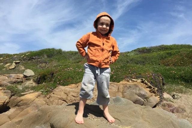 kid standing on bean hollow beach california in winter