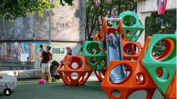 geometric climbing structures in orange and green at Auntie Chin Park one of the best playgrounds in Boston