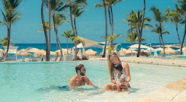family in a pool at all-inclusive resort with baby care