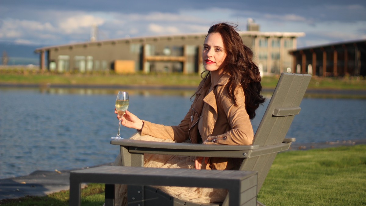 a woman sits with a glass of wine outside Eritage Resort a girls weekend trips from seattle destination