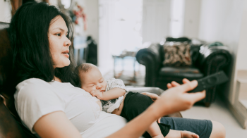 mom watching r-rated movies while holding newborn