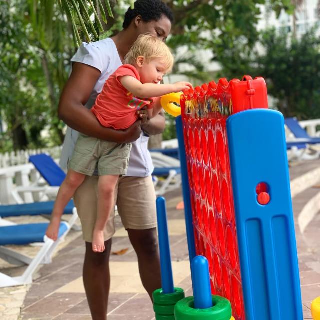 baby and vacation nanny playing a game at all-inclusive resort