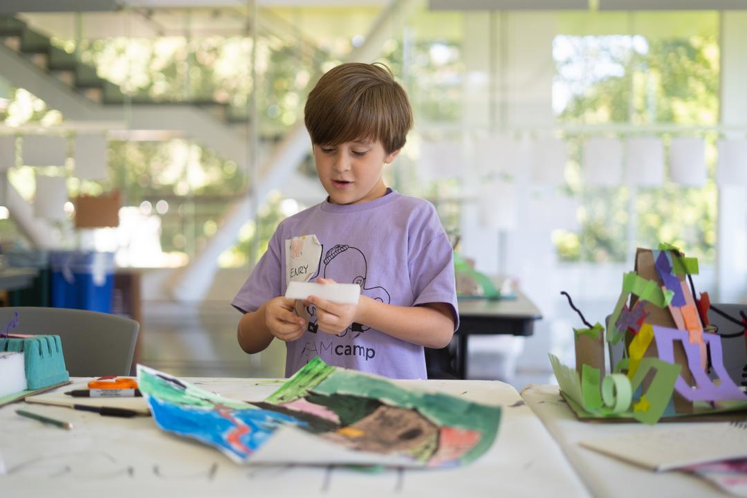a boy works on an art project with SAM during a Seattle summer camps