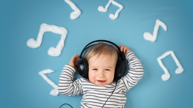 a little baby with headphones surrounded by clouds shaped like music notes listening to a spotify playlist for kids and families