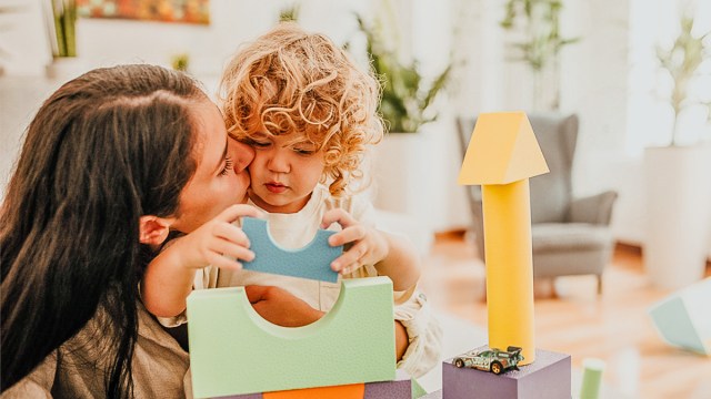 a mom playing blocks with her toddler and not worrying about developmental milestones