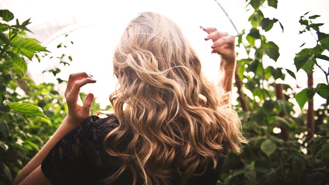 a woman with beach wavy hair, one of the possible body changes after pregnancy that can occur