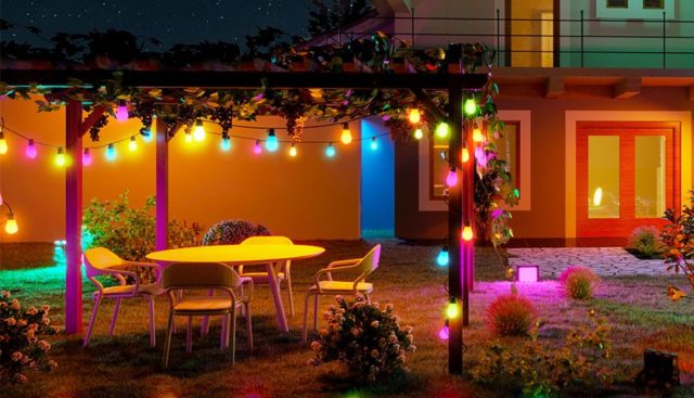 colorful string lights wrapped around an outdoor pergola