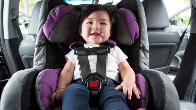 a baby sits rear facing in a car seat, happy they do not have motion sickness for kids