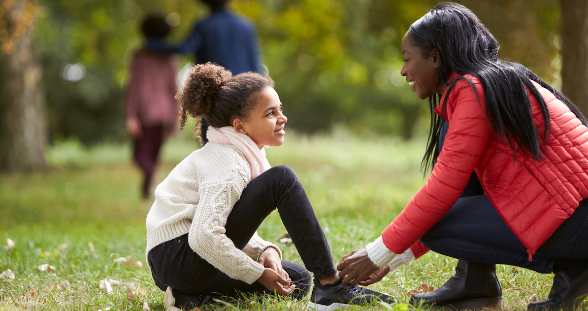 Young,Black,Woman,Helping,Her,Daughter,To,Tie,Her,Shoes