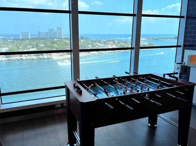 Foosball table in teen club on Sky Princess cruise next to floor to ceiling windows overlooking the water