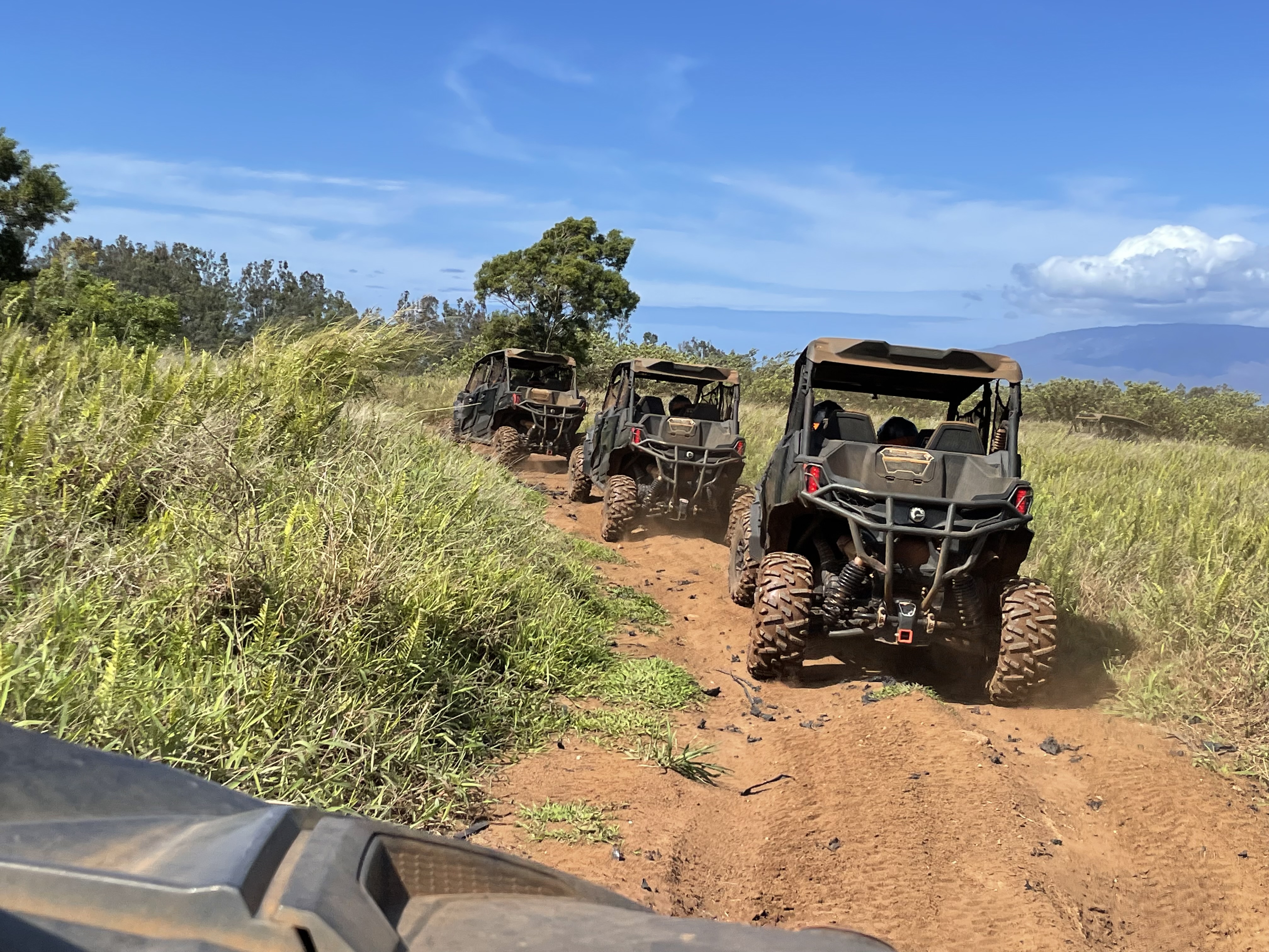 ATVs on Maui island with a blue sky and rugged terrain