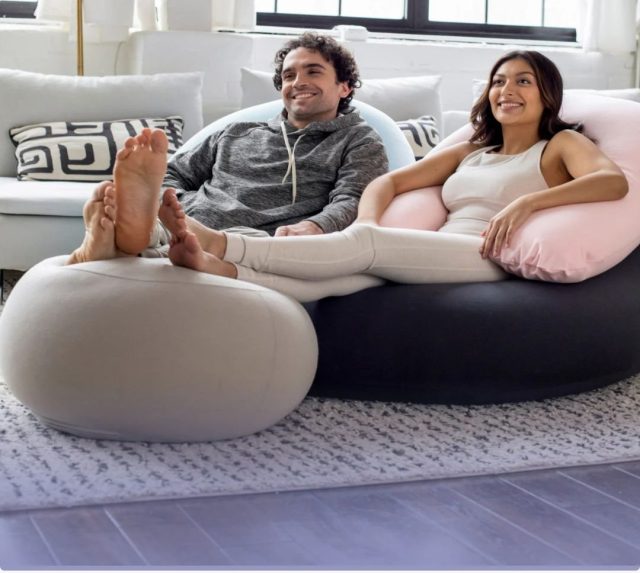 a man and woman lounging on luxe beanbag chair and ottoman