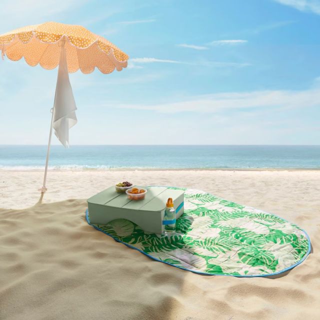 green leaf picnic blanket on beach