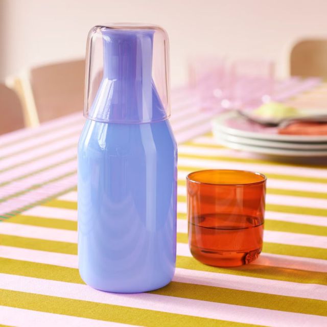 light blue carafe and glass on table top
