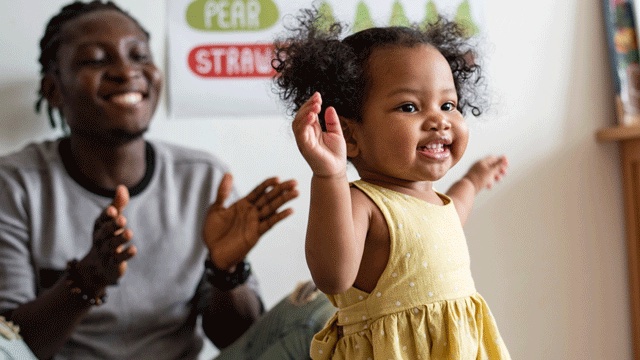 a toddler dances in a yellow dress in front of her dad, toddler activities
